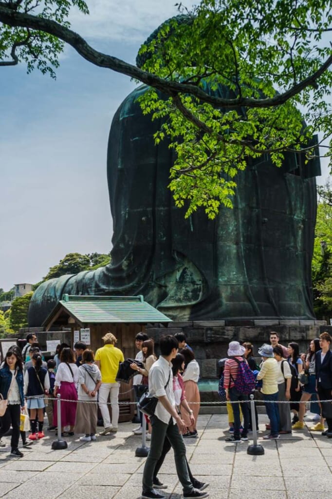 Kamakura Daibutsu or Great Buddha of Kamakura from behind with people lining to see the interior