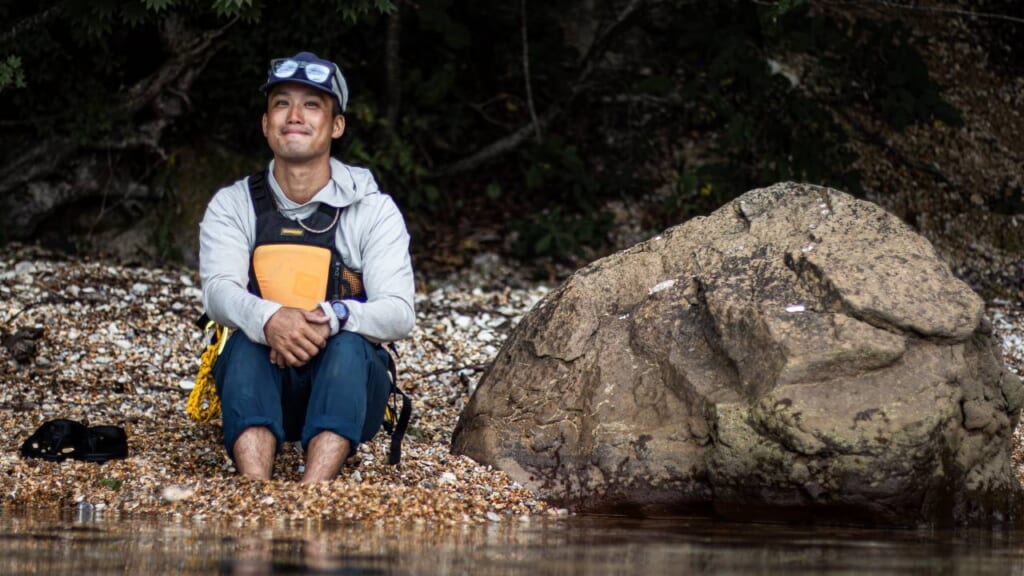 person sitting at the water's edge