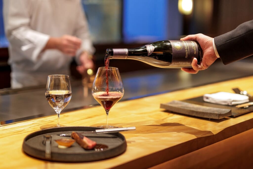 person filling a wine glass