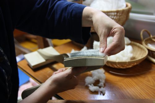 Lisser les fibres de coton avant de fabriquer le Yumihama-gasuri, à Yonago, préfecture de Tottori, Japon