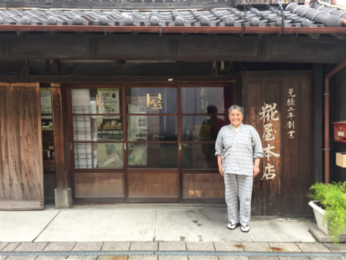 Mme Asari devant la façade traditionnelle de sa fabrique de koji à Saiki, Oita