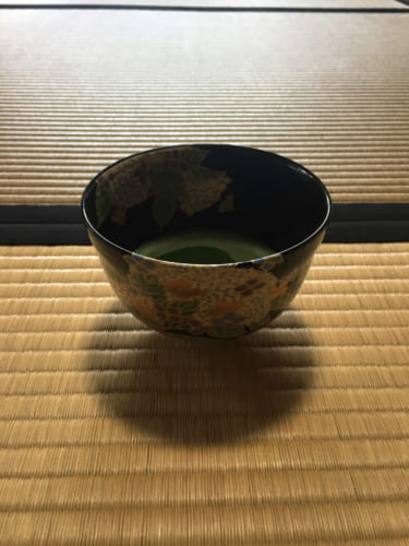 Bol de thé vert matcha posé sur le sol en tatami dans une maison de thé à Saiki