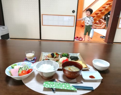 Petit déjeuner traditionnel au Minshuku Maroudo, le petit-fils des propriétaires observe la scène de loin, à Takachiho, Miyazaki, Kyushu