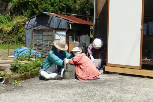 Épouvantails de tissus devant des bâtiments sur le chemin du sanctuaire d'Akimoto
