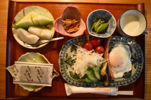 Petit déjeuner varié : fruits, légumes, œufs, etc. dans de la vaisselle japonaise