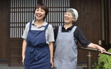 Yuri et sa mère, tout sourire devant leur maison d'hôtes à Ubuyama