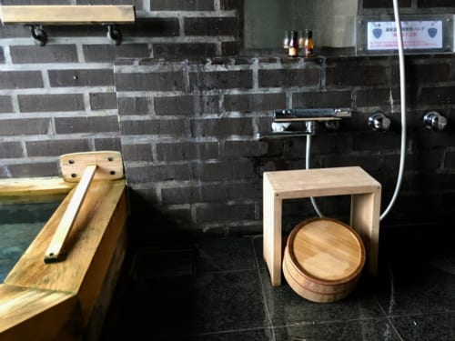 L'onsen privatif et son coin douche, équipé d'accessoires en bois clair