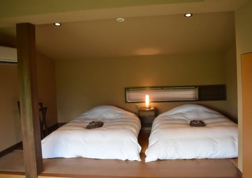 Deux lits à l'occidentale, préparés dans la chambre à la décoration japonaise sobre