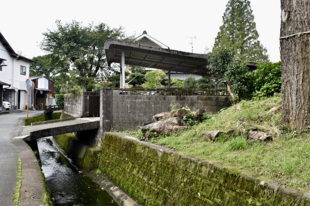 Ruelle dans le quartier près du sanctuaire d'Aso : un pont de pierre permet d'entrer dans une propriété