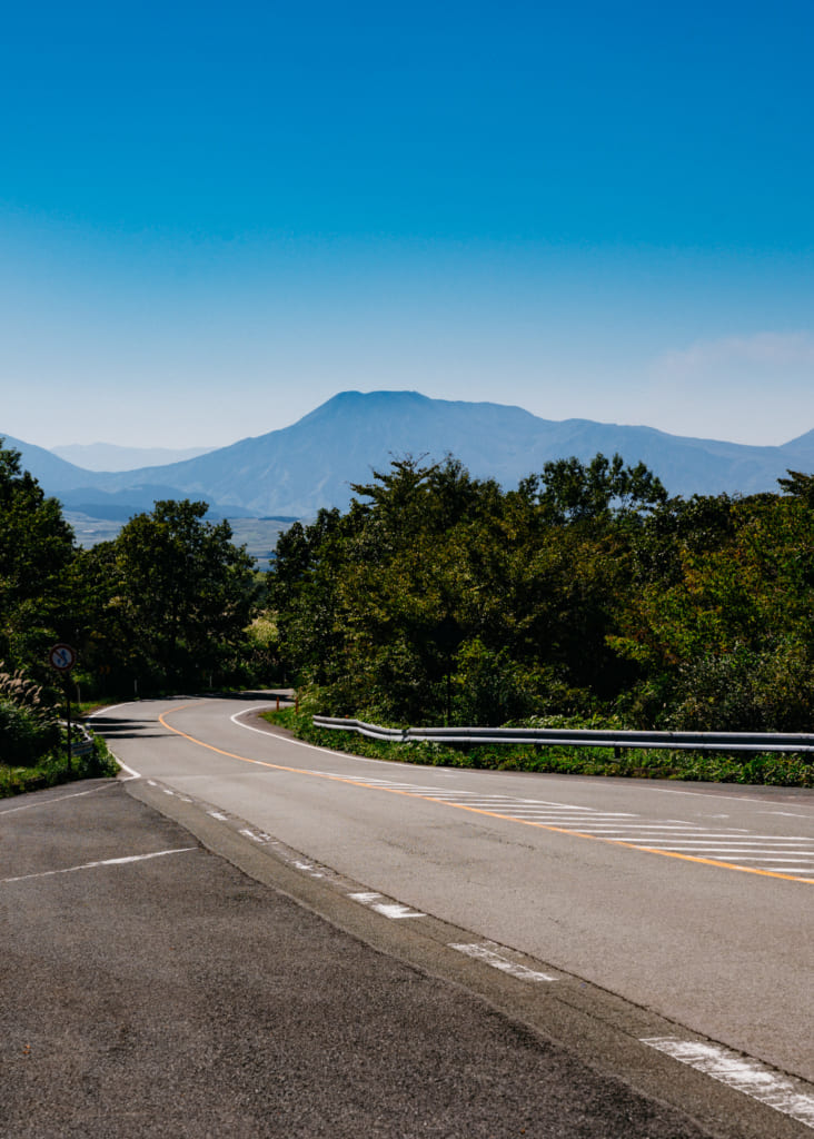 La route descend dans un paysage de montagne à Aso , Kumamoto