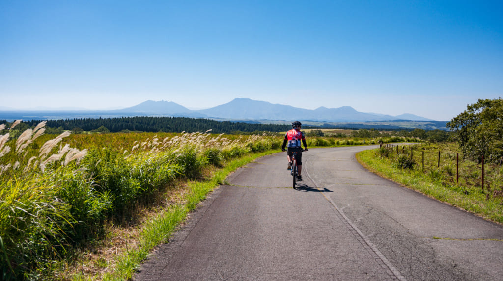 Le guide sur son vélo sur les routes de la caldeira du mont Aso