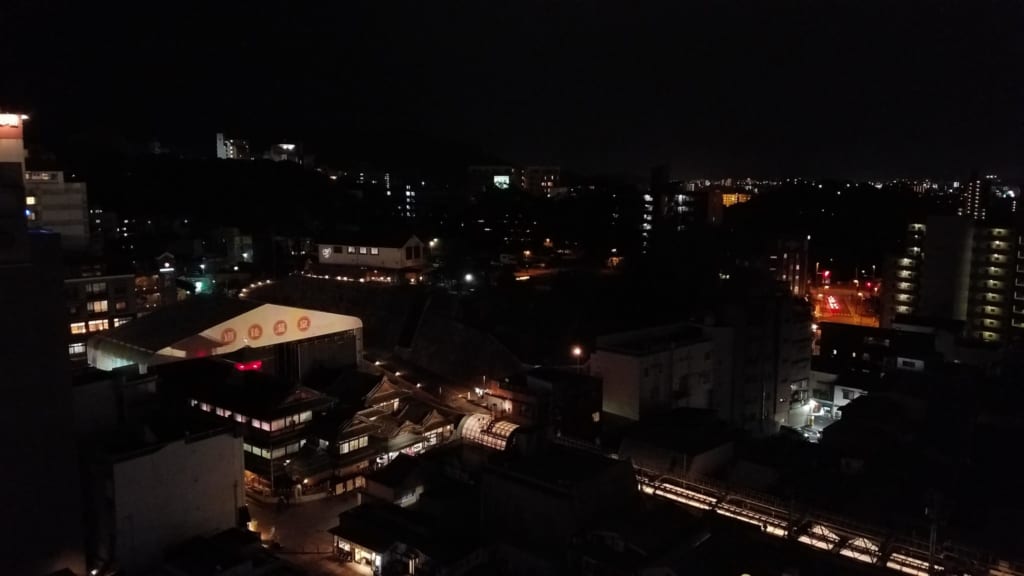le Dogo Onsen Honkan de nuit vu depuis une chambre de l'hôtel Kowakuen Haruka