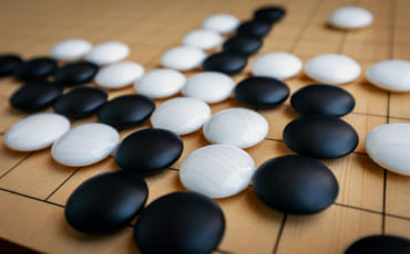 pierres d'un jeu de go posées sur un goban