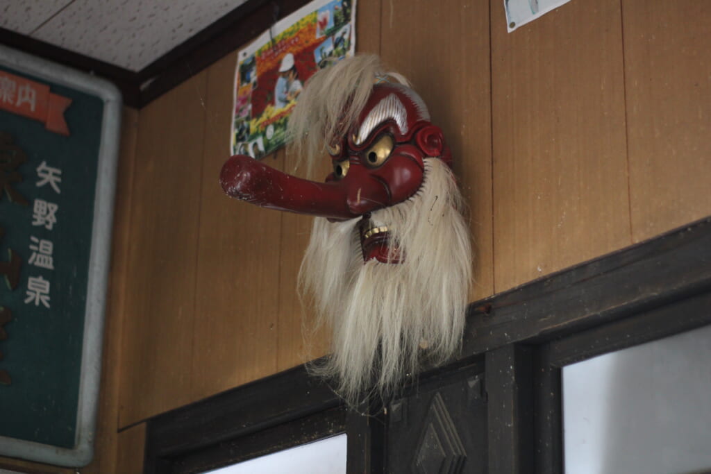 un masque traditionnel japonais aux murs d'une petite gare