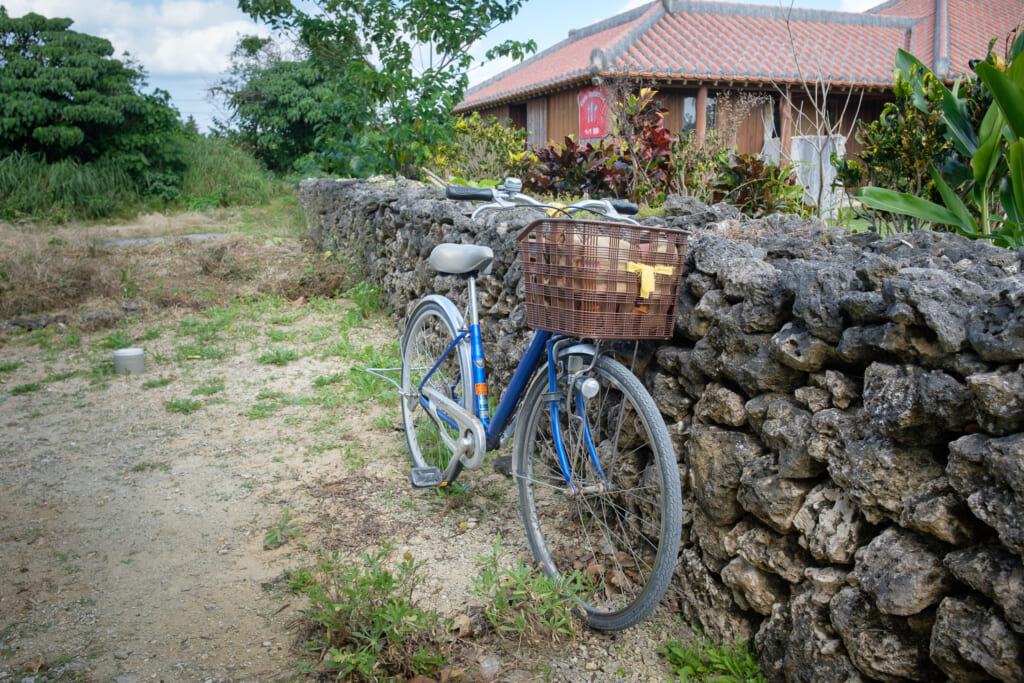 Un vélo contre un murret de pierre à Taketomi