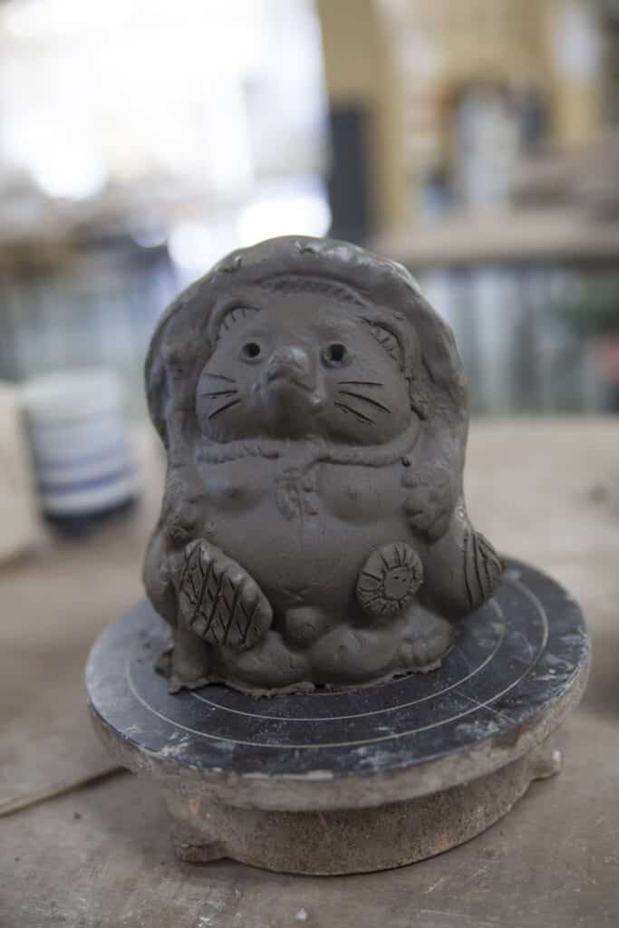 statue de tanuki en argile prête à passer au four