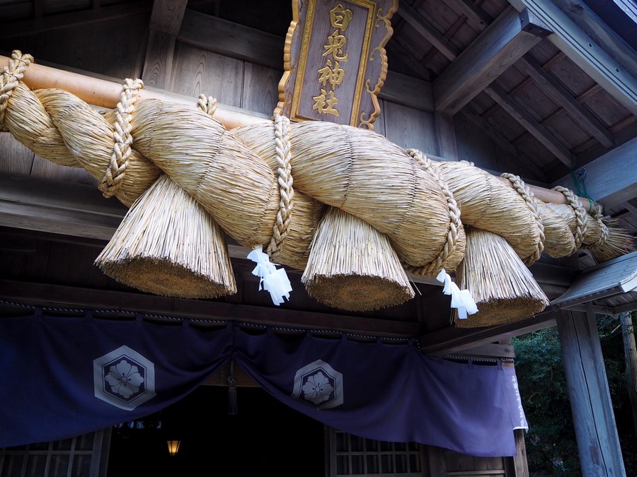 immense corde tressée sur la devanture d'un sanctuaire japonais
