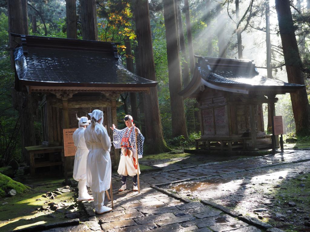 Guide yamabushi conduisant des visiteurs dans la forêt du mont Haguro