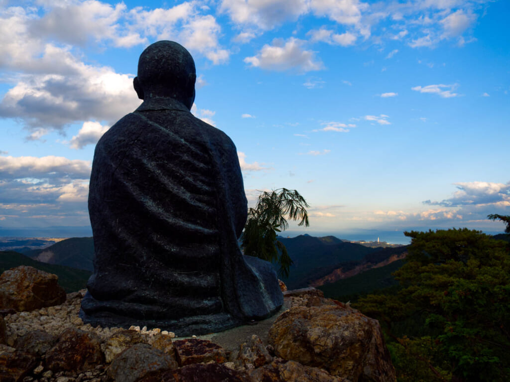 Statue d'un moine bouddhiste observant l'horizon