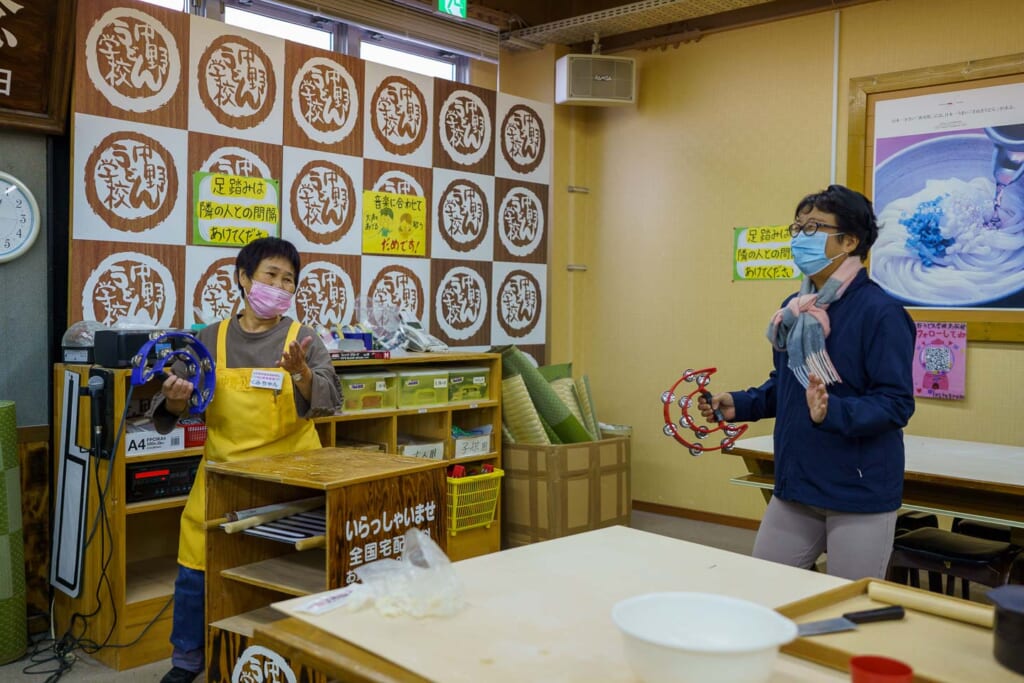 deux japonais jouent du tambourin dans un atelier de udon