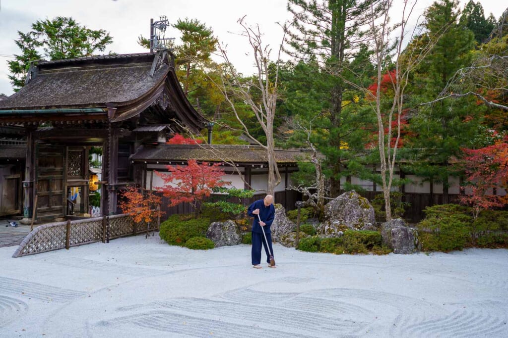 Un temple trace des lignes dans le gravier d'un jardin sec au Japon