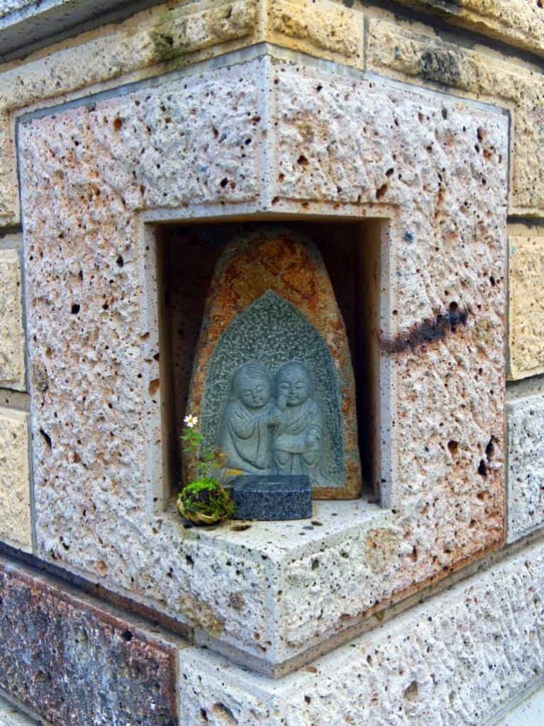 Statue bouddhiste au coin d'un mur au Japon