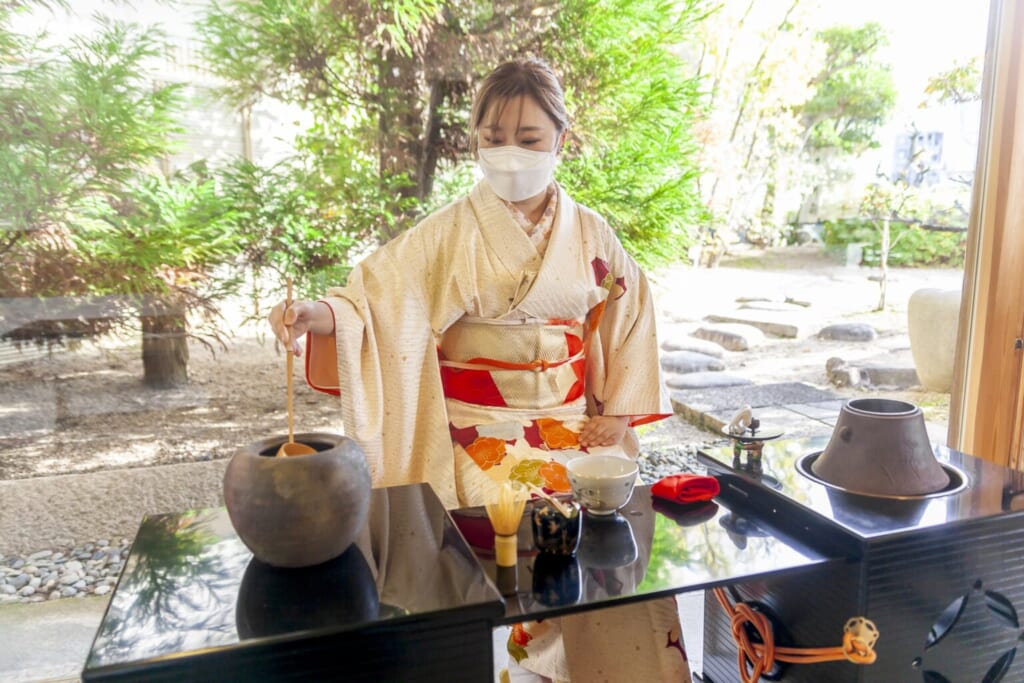 Japonaise pratiquand la cérémonie du thé en kimono
