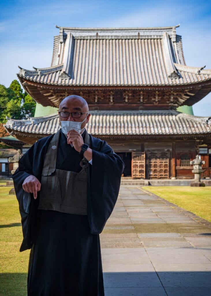 un moine japonais devant un temple bouddhiste