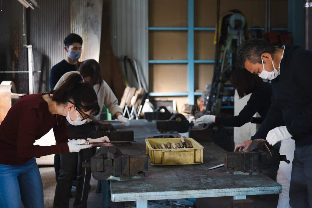 Des visiteurs prennent part à une initiation dans un atelier de coutellerie au Japon