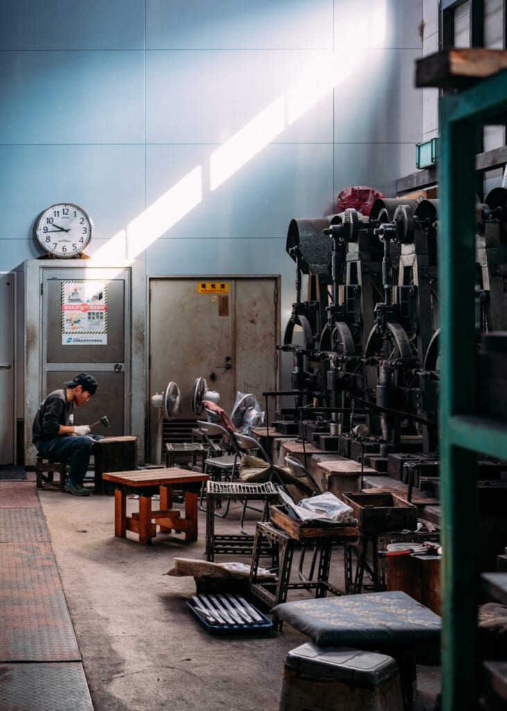 Un artisan au travail dans un atelier japonais de coutellerie