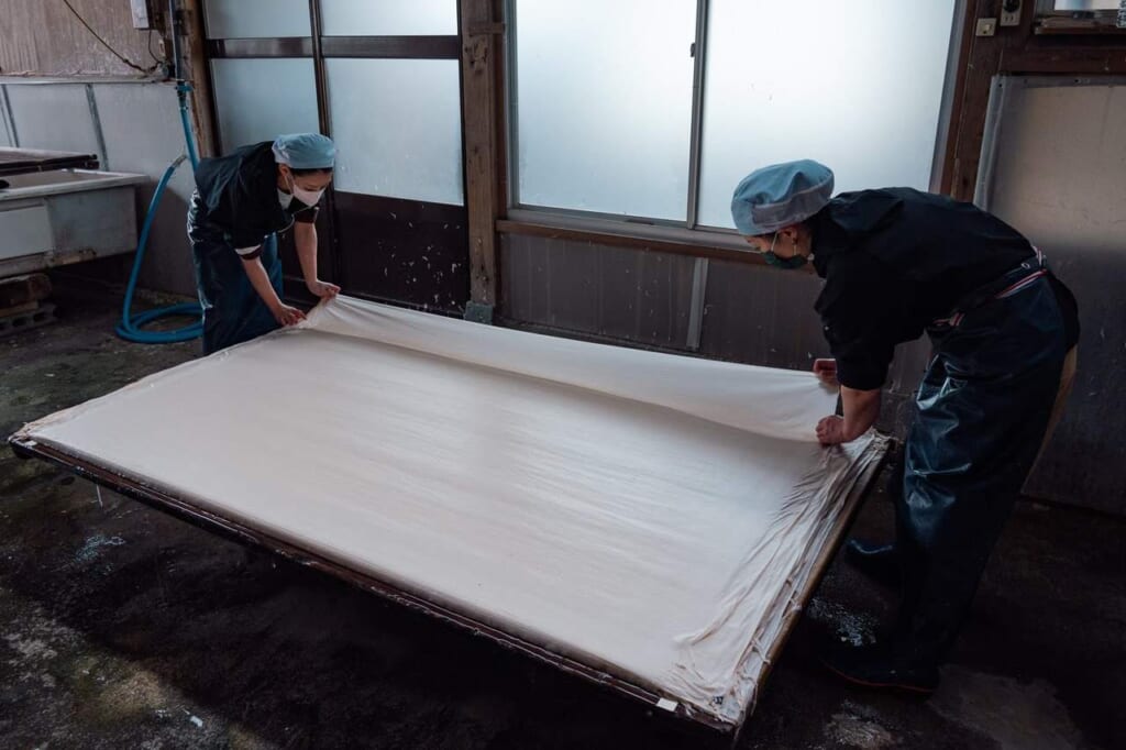 Deux artisanes entrain de fabriquer une feuille de papier washi
