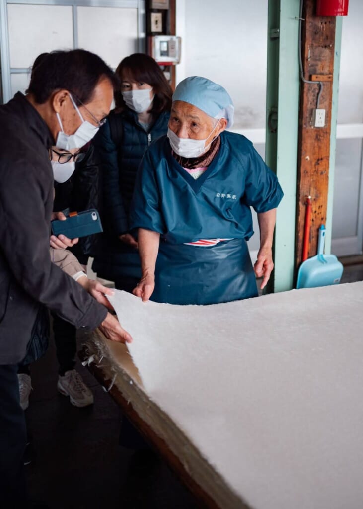 Une artisane d'Echizen montre aux visiteurs la qualité du papier washi