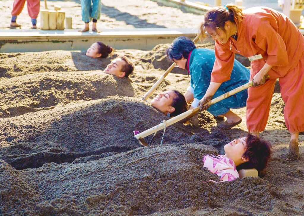 visiteurs prenant un bain de sable dans une ville onsen au Japon