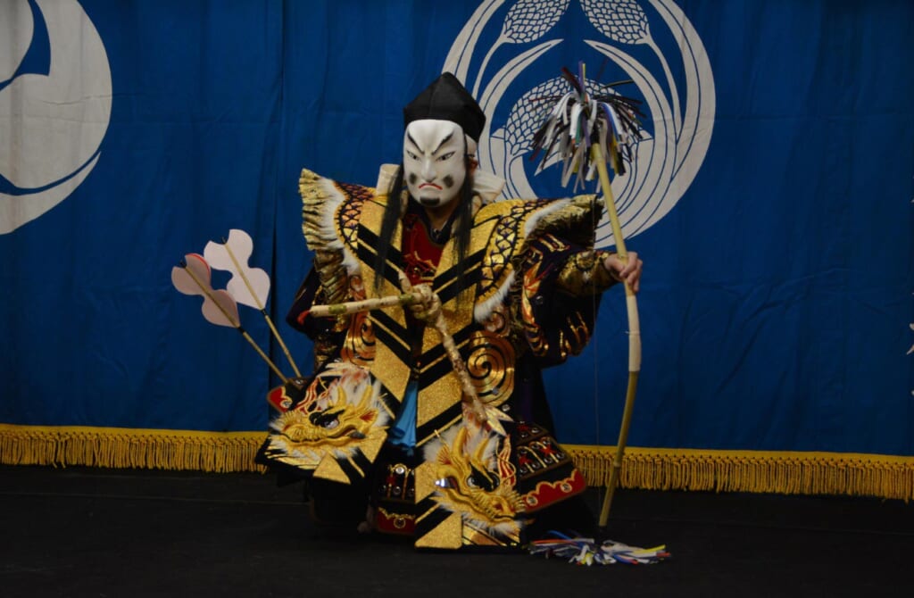 Un danseur de kagura combat un démon avec des flèches