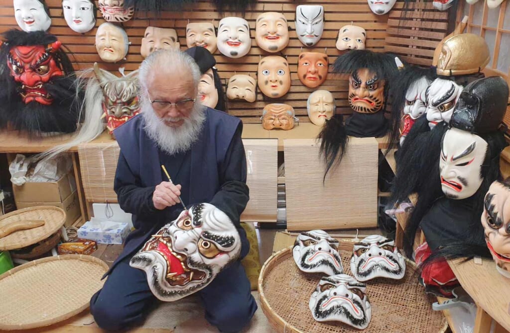 un artisan japonais travaillant sur un masque de démon pour des représentations d'Iwami Kagura