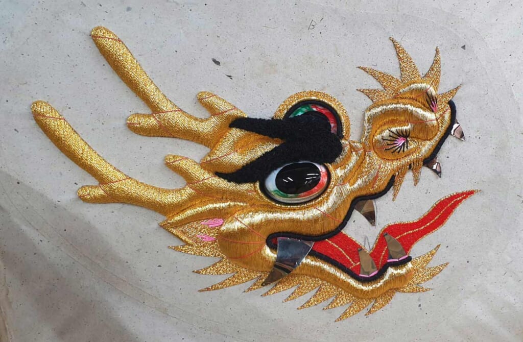 La tête d'un serpent, finement brodée sur un costume traditionnel japonais
