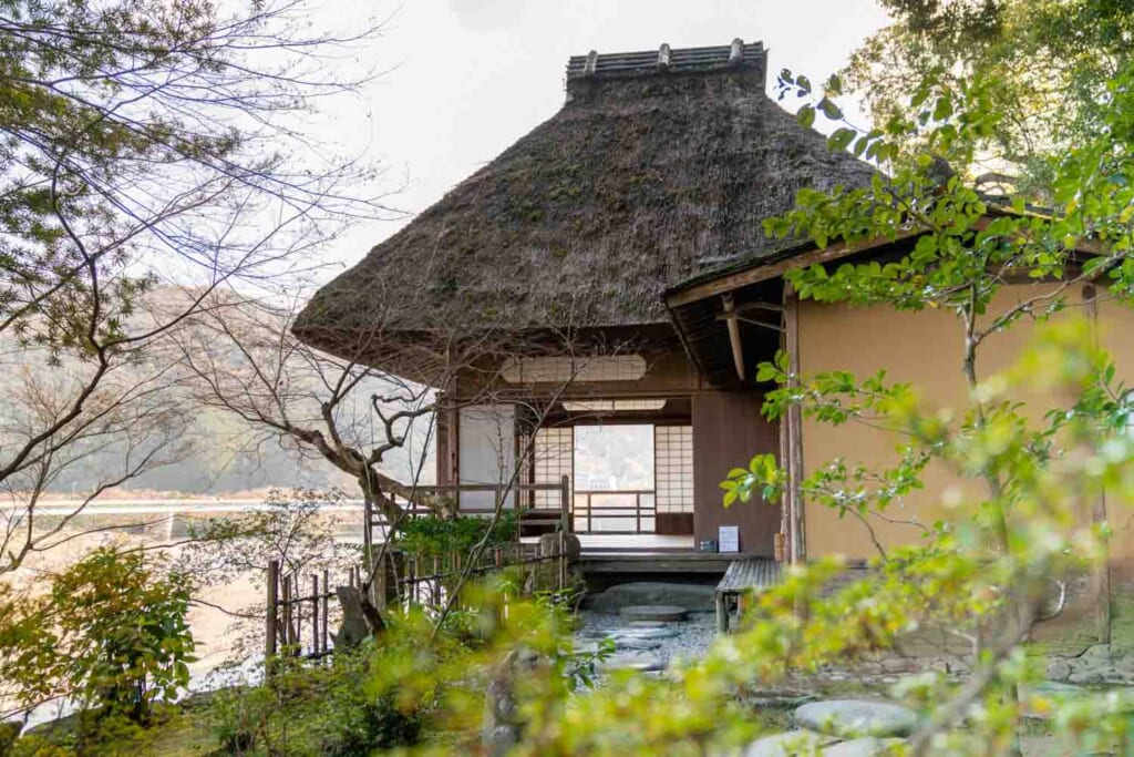 Une maison de thé japonaise avec un toit en chaume
