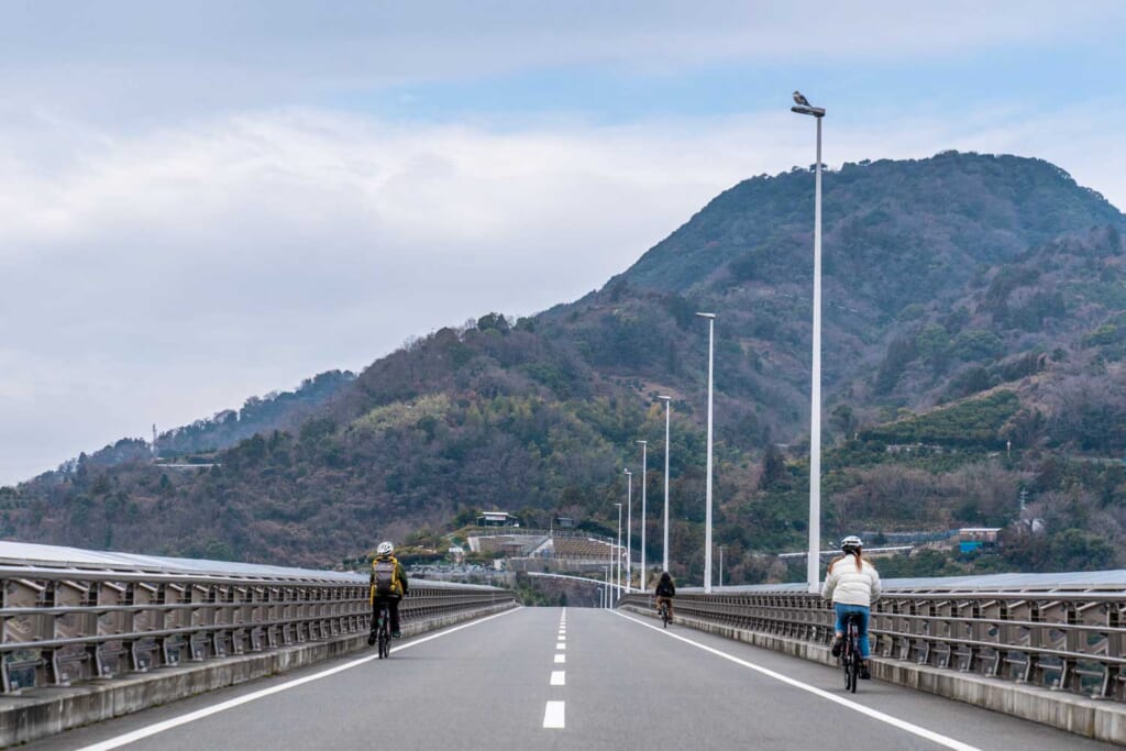 Des cyclistes sur un pont japonais dans une région rurale de Shikoku