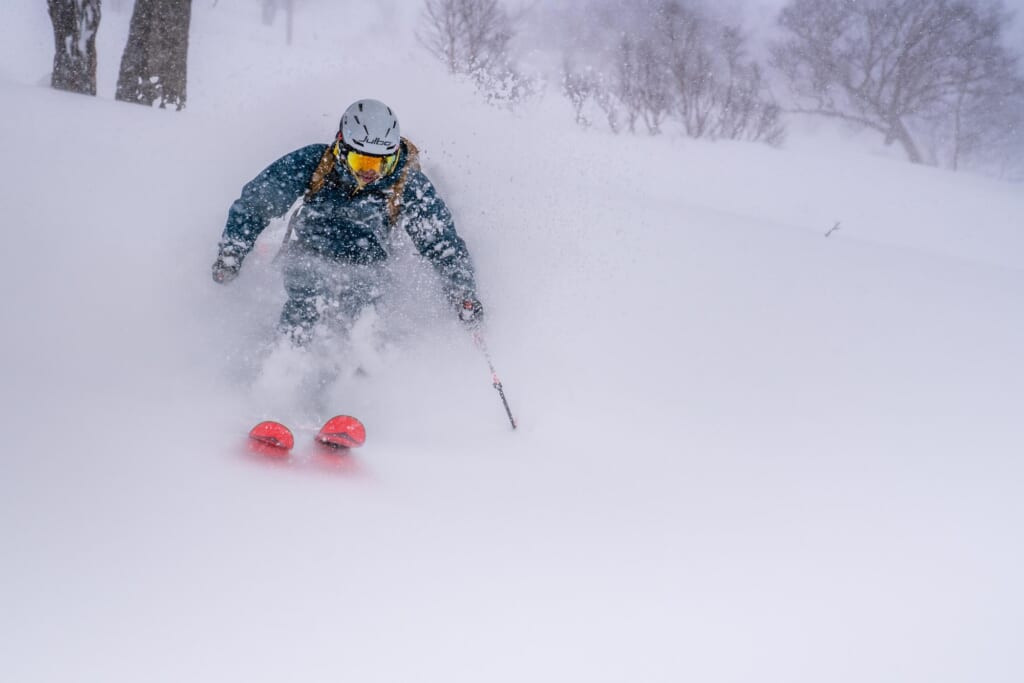 Un skieur dévale une pente dans une épaisse neige poudreuse