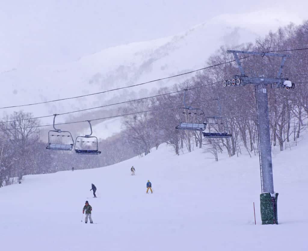 télésiège passant au-dessus d'une piste de ski dans un domaine skiable japonais à Hokkaido