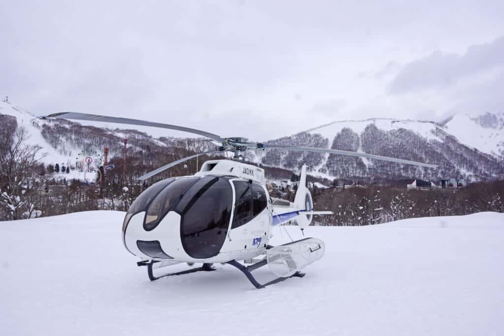 Un hélicoptère d'héliski dans les montagnes enneigées d'Hokkaido