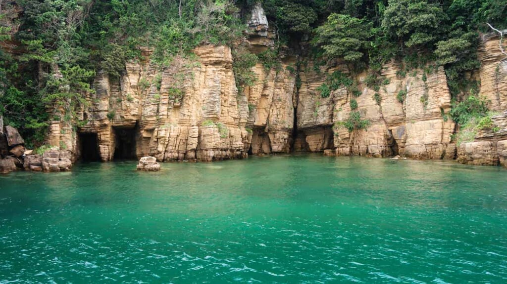 Croisière en bateau à Iki. Grottes dans la falaise.