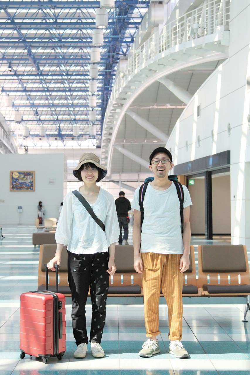 Deux personnes sont sont dans un aéroport et portent des pantalons à carreaux en Kurume kasuri