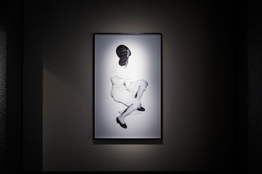 Collage photo noir et blanc de Frida Orupabo représentant une femme assise en 3/4 dos, exposée à Okayama Art Summit 2022
