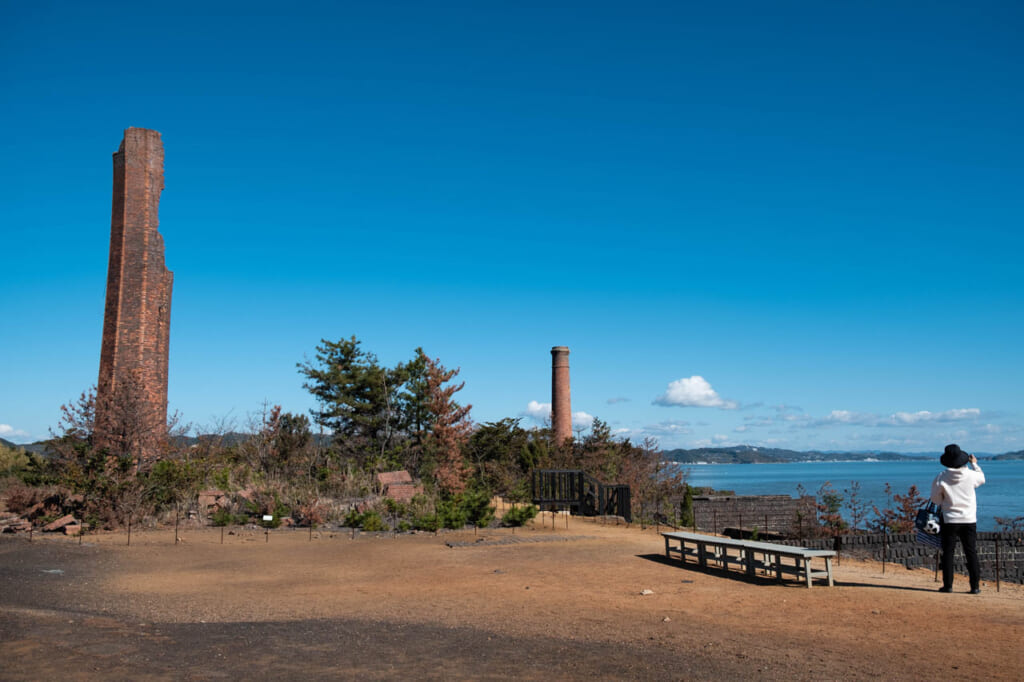Vue sur les hauteurs du musée Seirensho à Inujima : cheminées industrielles en briques et vue sur la mer