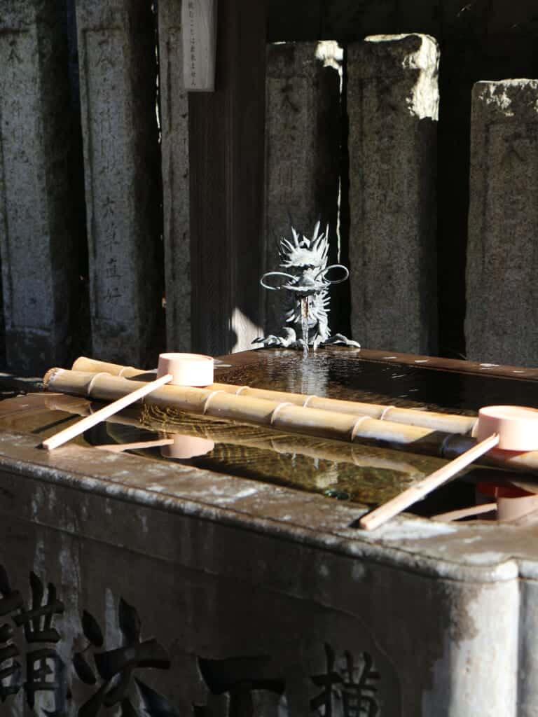 Lieu pour se rincer les mains dans un sanctuaire japonais avec une statue de dragon