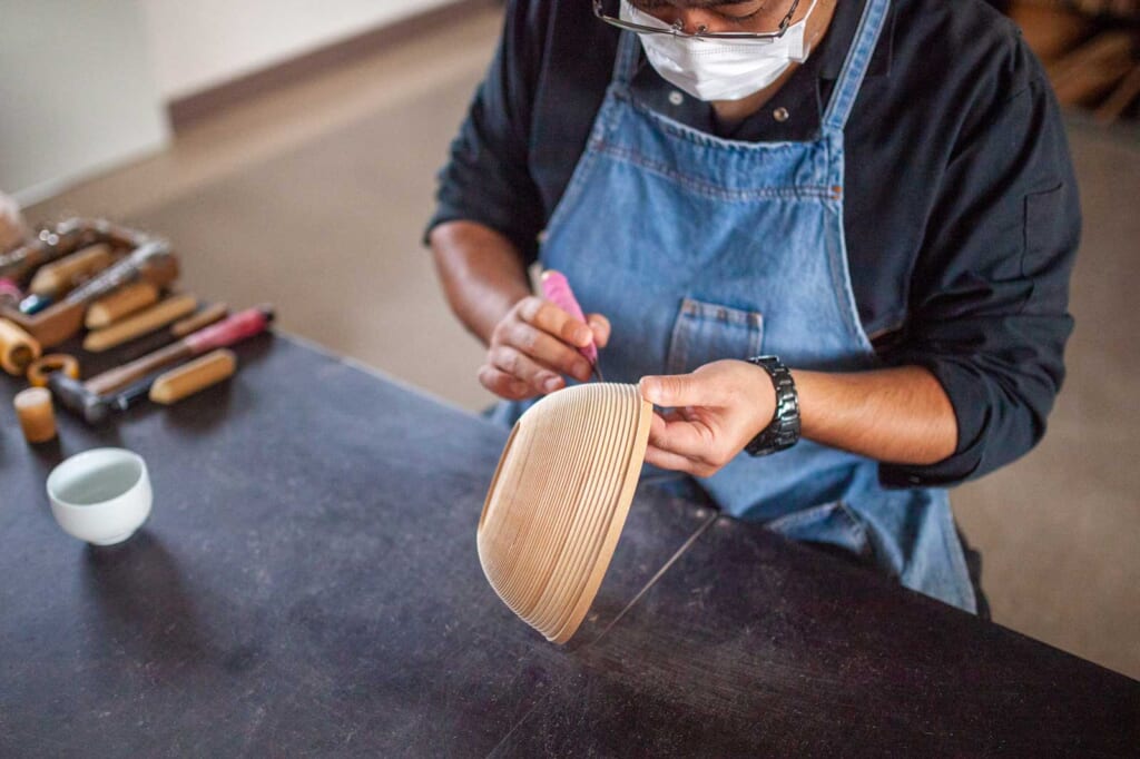 Un artisan japonais travaillant sur un bol en bois à Aomori