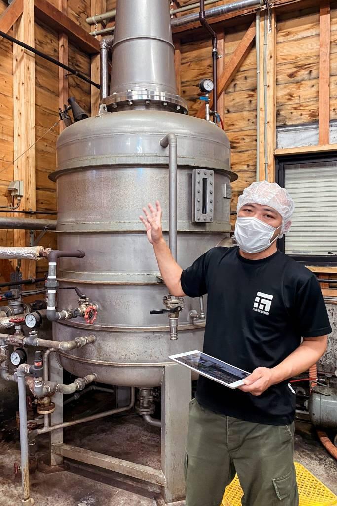 Un producteur de shochu devant une cuve de distillation au Japon