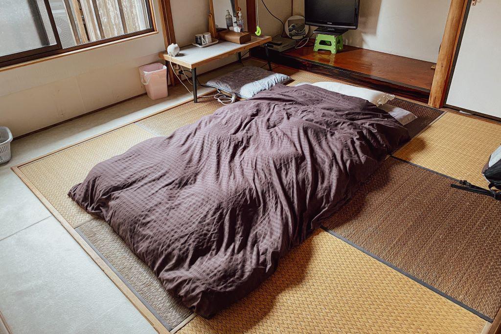 Futon déployé sur le sol en tatamis d'une chambre d'hôtes japonaise