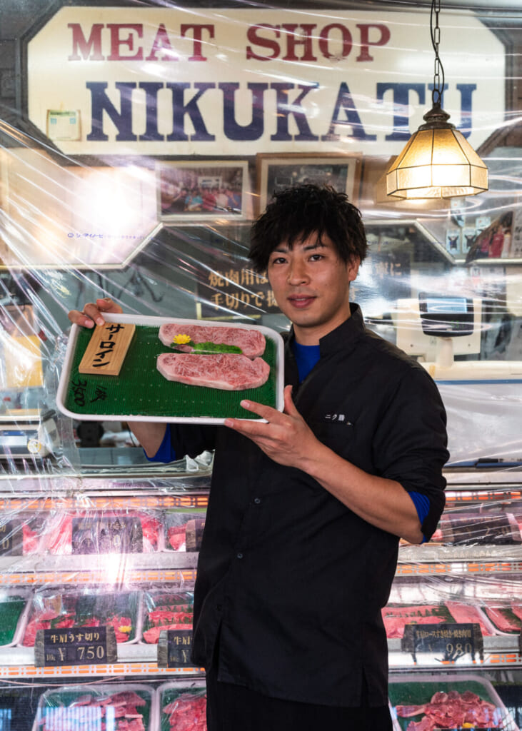 homme montrant deux morceaux de bœuf wagyu sirloin au MEAT SHOP NIKAKATSU au Japon